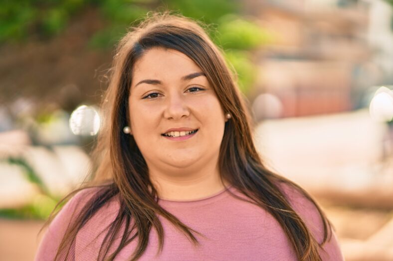 Young Hispanic plus size woman smiling happy standing at the city.