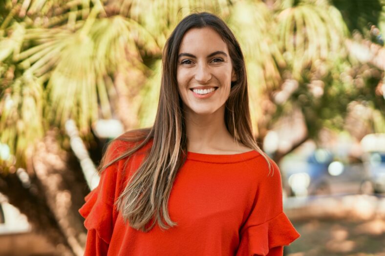 Young hispanic woman smiling happy standing at the park.