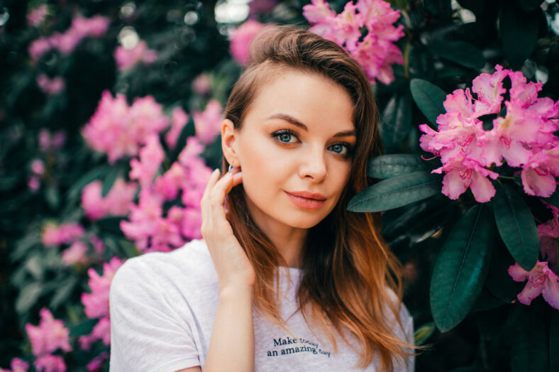 Young beautiful girl posing among the flowering tree