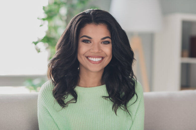 Portrait of attractive gorgeous cheerful girl sitting on couch staying in flat apartment indoor.