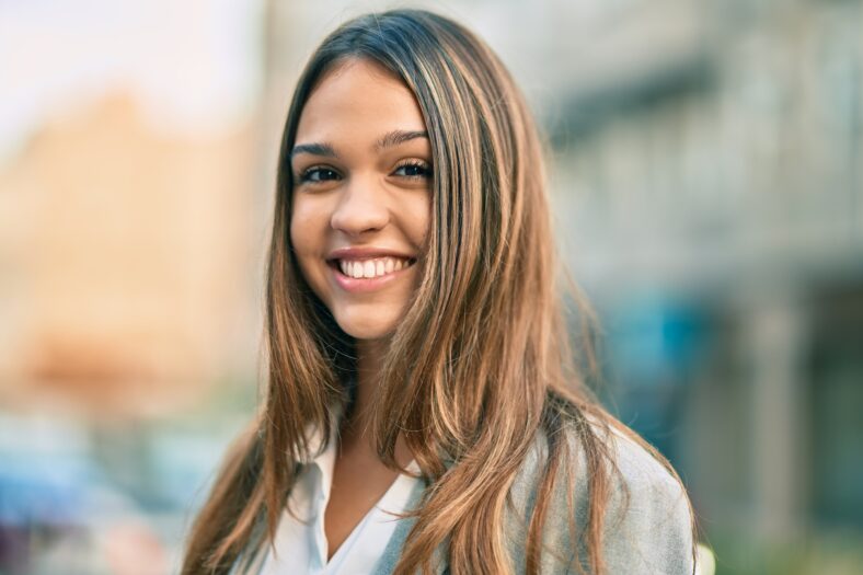 Young latin businesswoman smiling happy standing at the city.