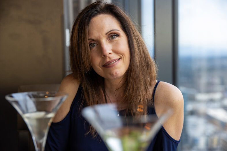 Pretty middle aged woman drinking a martini at a restaurant