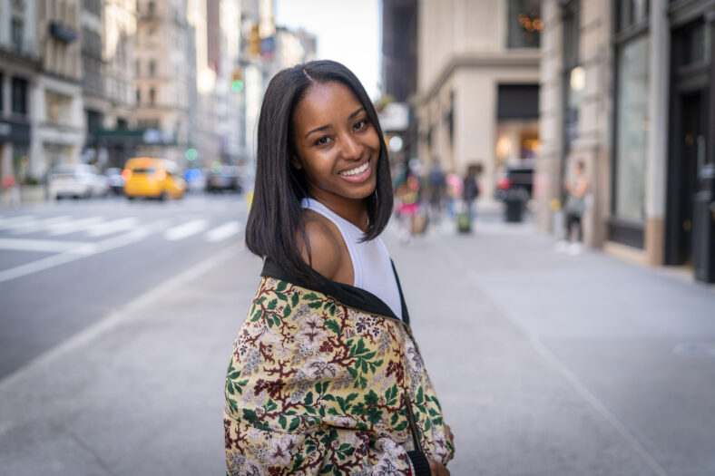Young black woman in city flirting with camera smile face