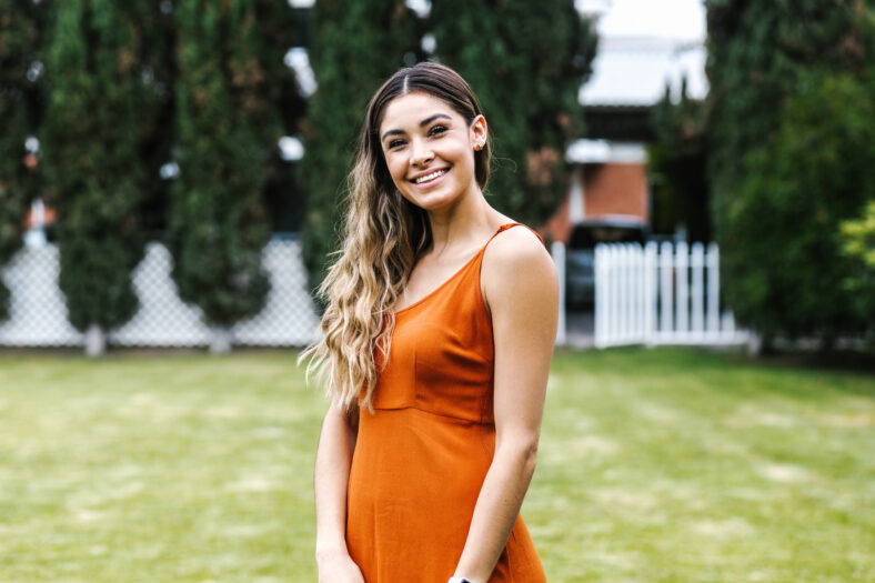 pretty woman in an orange dress standing on the lawn