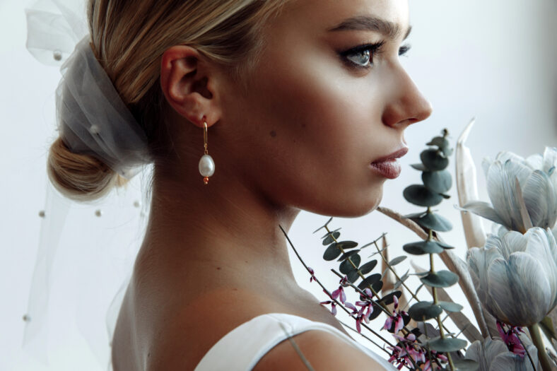 Facial portrait of a bride with a bouquet. Bride morning. White background.