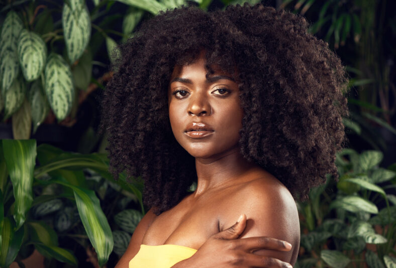 Shot of a beautiful young woman posing against a leafy background.