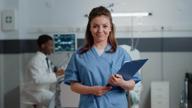 Portrait of woman nurse with medical files to give support to medic in hospital ward. Close up of medical assistant looking at camera ready to help with patient and checkup documents.
