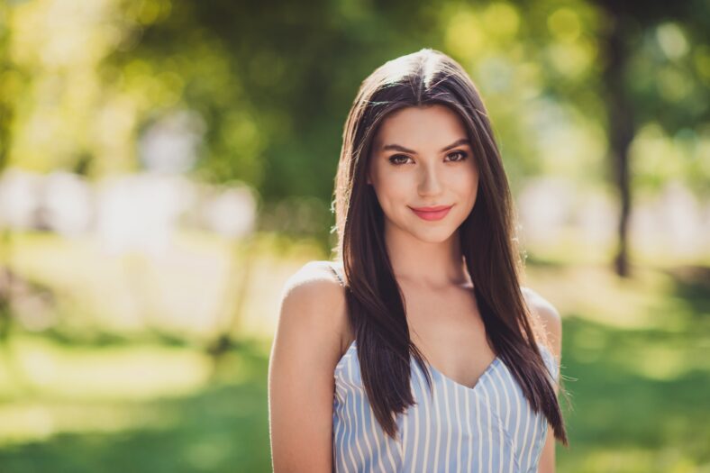 Photo of nice looking positive mood girl with long straight hairstyle go walk with friends outdoors in city park .