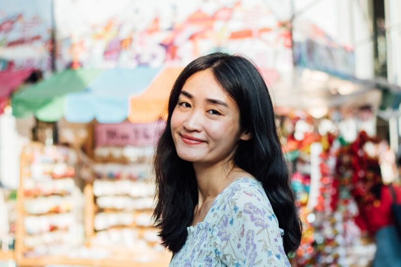 Close up of beautiful Asian woman with city blurred background.