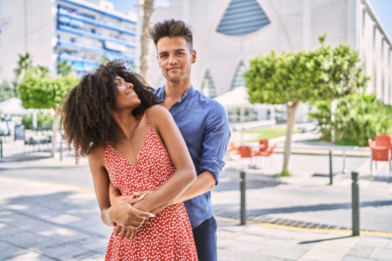 Man and woman couple smiling confident hugging each other standing at street