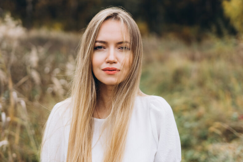 Outdoor atmospheric lifestyle portrait of young beautiful blondie lady. Warm autumn. Beautiful cheerful blondie woman