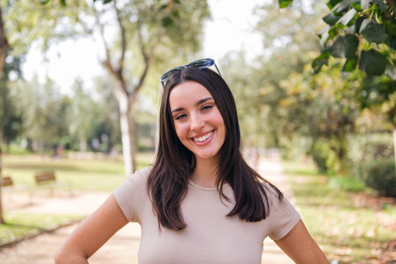 young caucasian woman looking at camera smiling with sunglasses on her head, concept of youth and beauty