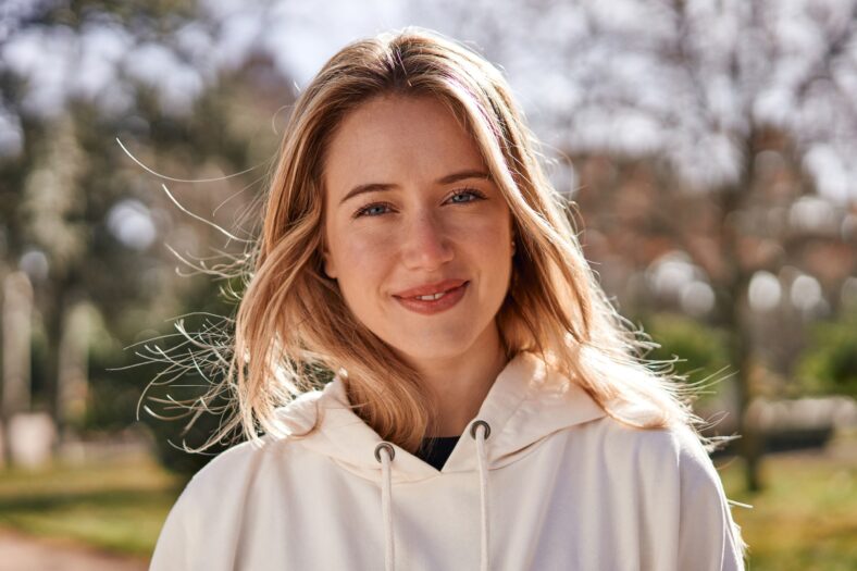 Joyful close-up of young caucasian woman in a park.