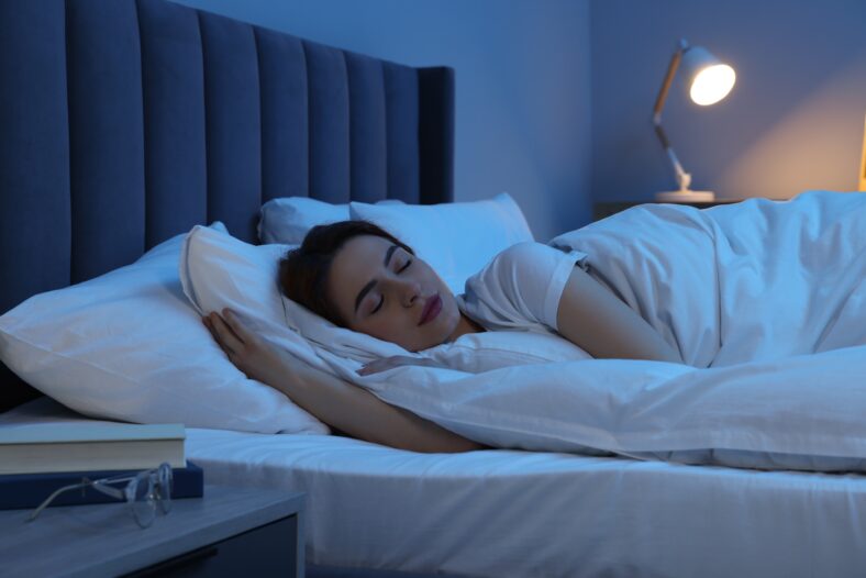 Beautiful young woman sleeping in bed at night