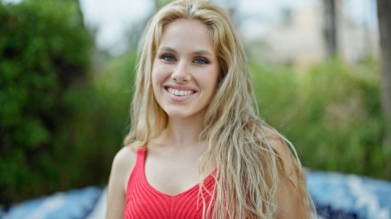 Young blonde woman smiling confident standing at park