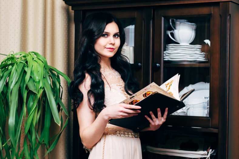Girl hostess in a restaurant holding hands in the menu