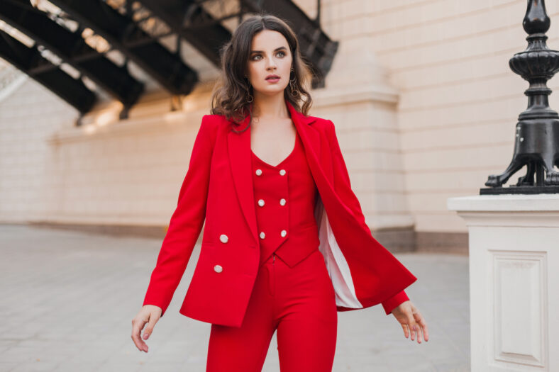 beautiful rich business woman in red suit walking in city street, spring summer fashion trend
