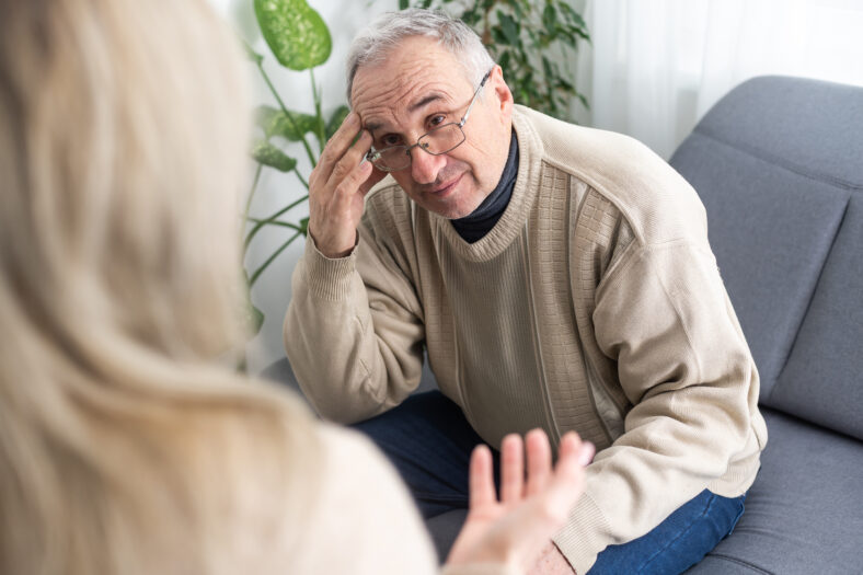 Mature man at a session with a psychologist. The doctor listens and writes. Help with depression, psychiatric diagnosis