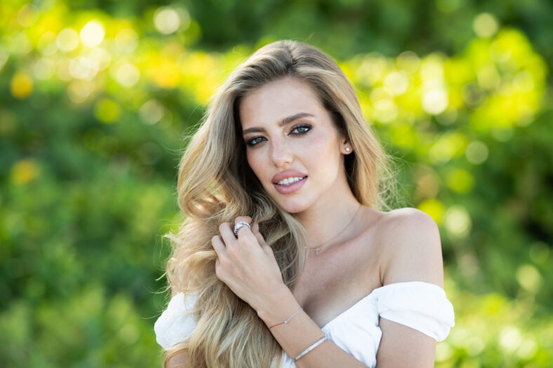 Beautiful woman enjoying spring. Attractive tender romantic girl on spring green nature background. Beautiful young woman with glamour make up outdoor portrait