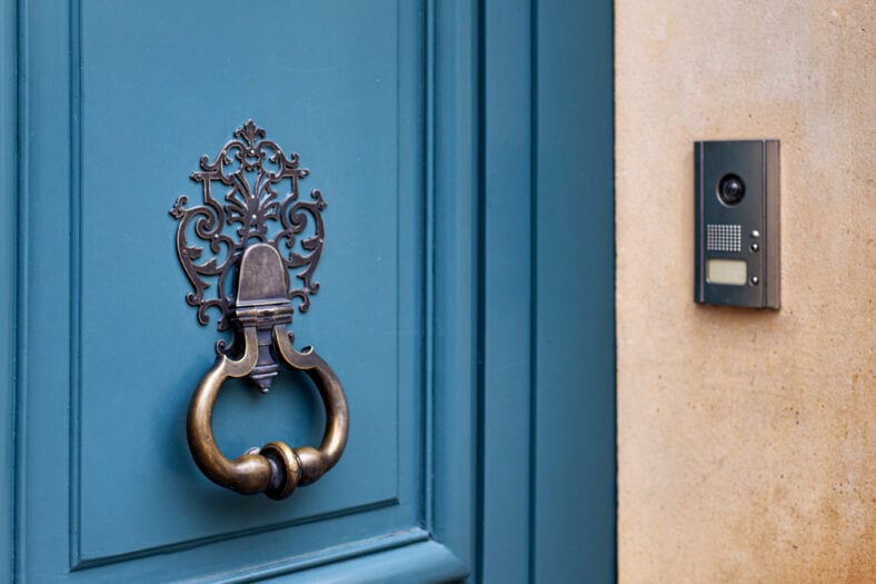 Old door knocker and modern doorbell