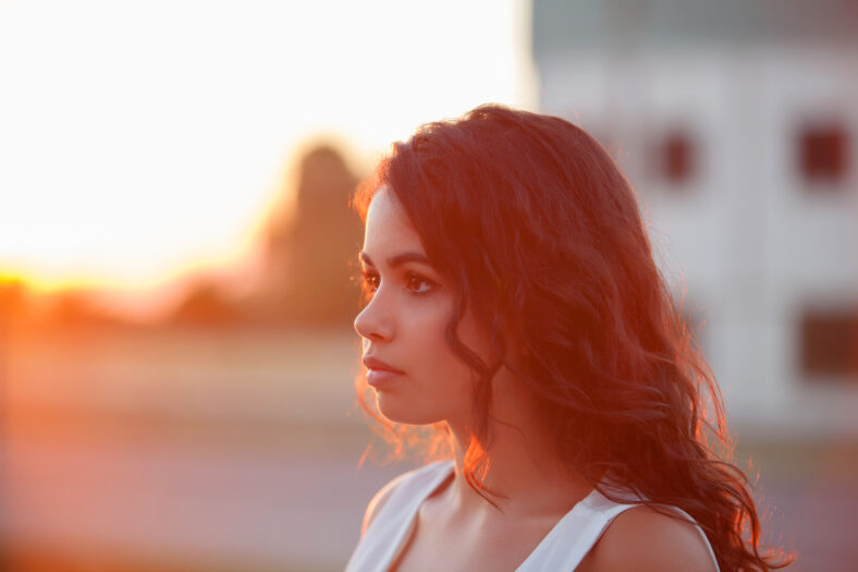 Beauty Sunshine Girl Portrait. Sunny Summer Day under the Hot Sun. Happy Woman Smiling and looking at camera.