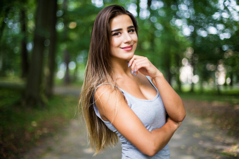 Outdoors portrait in park of a beautiful tanned teen student girl.