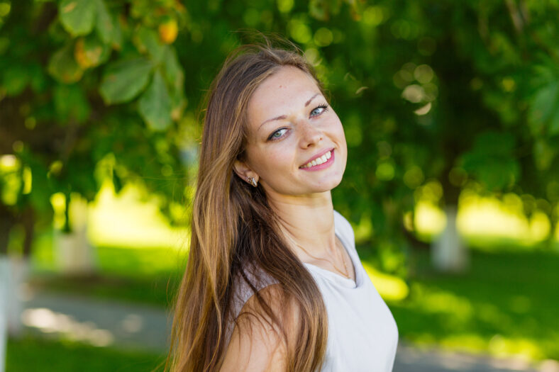 Portrait of a beautiful girl with long blond hair outdoors in summer