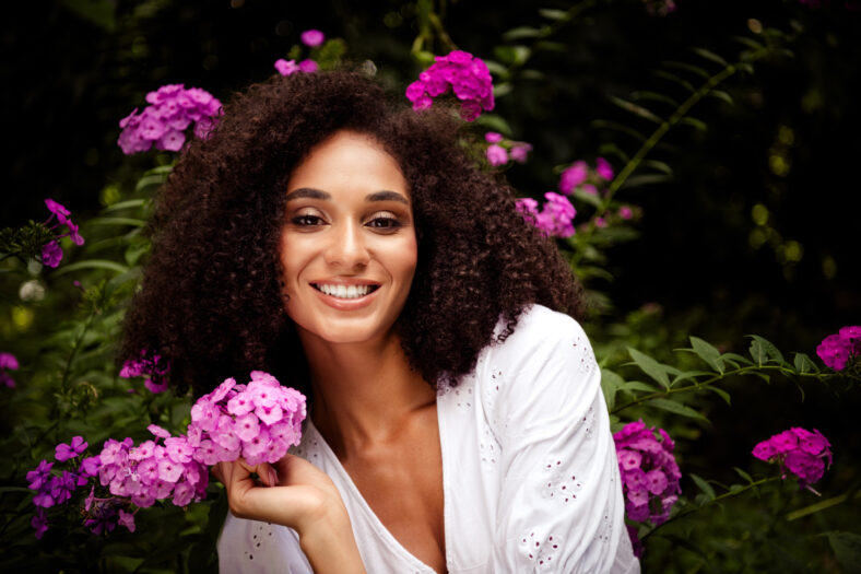 Photo of adorable cheerful girl dressed white stylish clothes enjoy blooming fresh flowers in botanical garden outdoors.