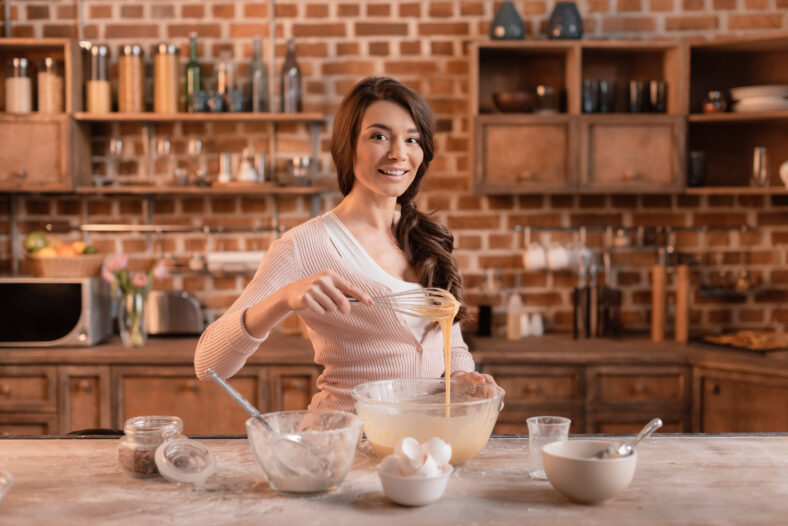 portrait of smiling woman mixing ingredients for cake