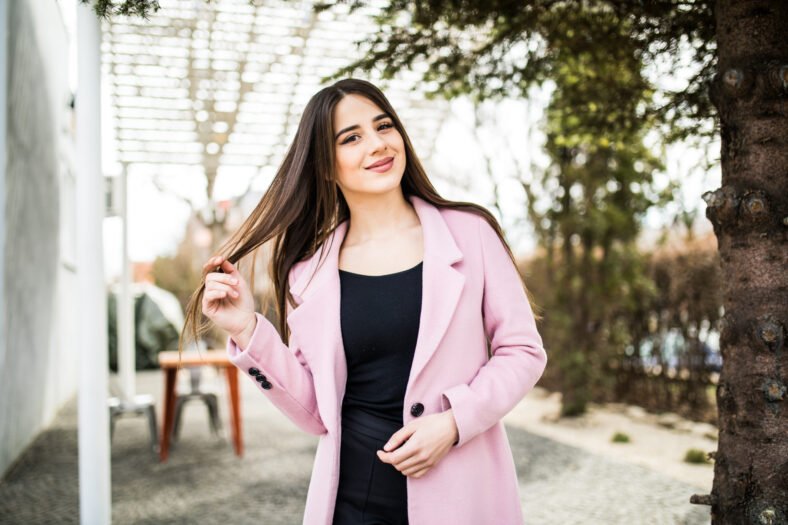 Portrait of cute girl smiling to camera in city street
