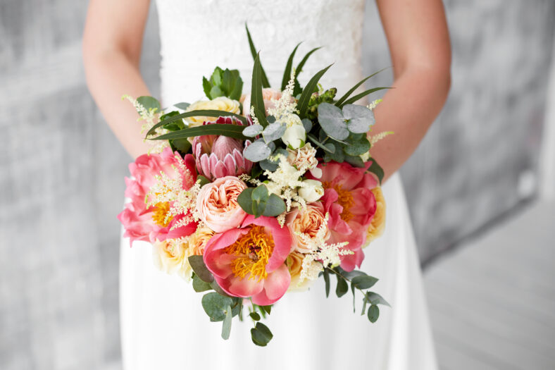 pink peony bouquet in hands of the bride