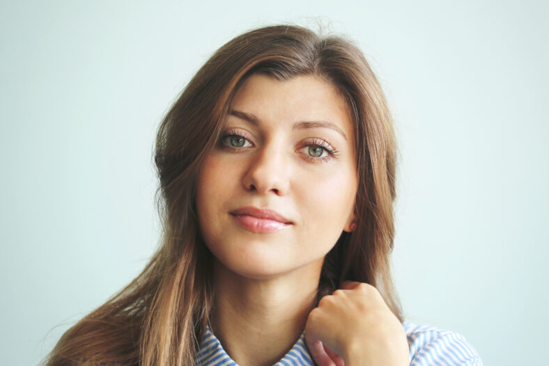 Young girl face with long dark hair on a blue background