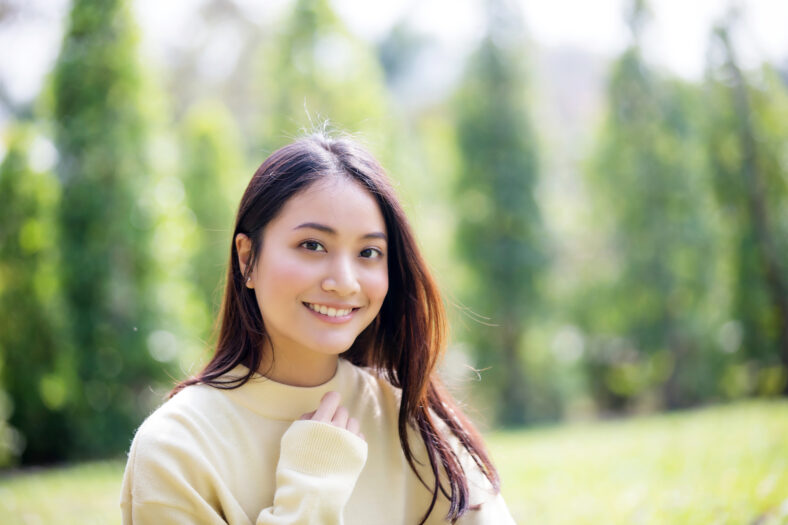 Beautiful Asian woman Smiling happy girl and wearing warm clothes winter and autumn portrait at outdoor in park