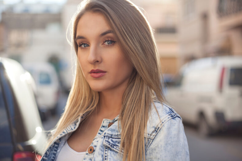 Beautiful blue eye model posing with narrow street in the background.