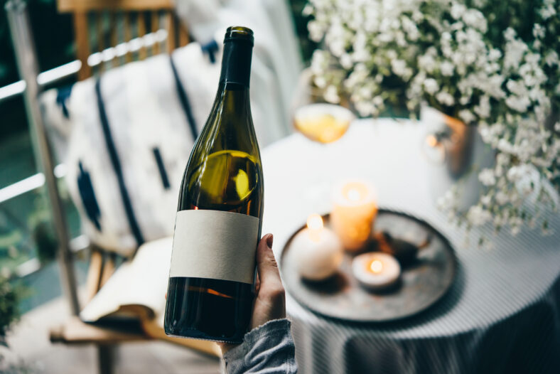 Wine bottle in hand. Blank label