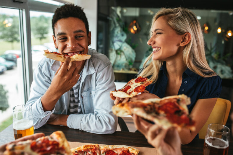 Shot of a young happy couple eating pizza in a restaurant