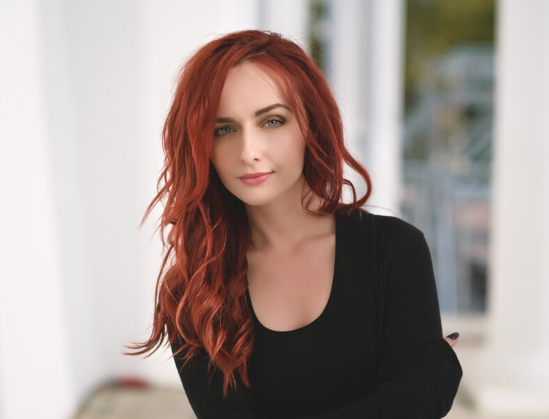 Retrato de atractiva mujer joven de cabello rojo con ojos azules.