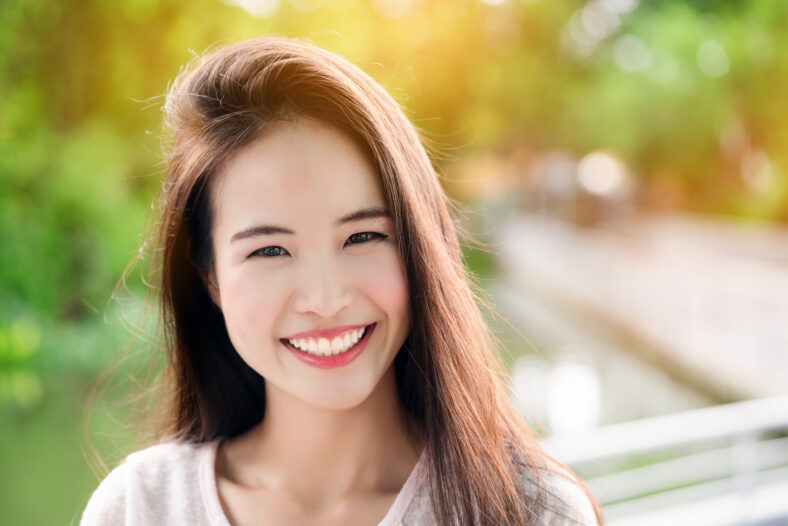 Adolescente asiática con cabello largo que está bien mantenido. La piel se ve hermosa. Tener una sonrisa brillante. Ella cuida sus dientes y la boca. Así que tenga confianza no en el estado de la depresión.