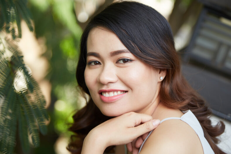 Face of beautiful happy young woman looking at camera