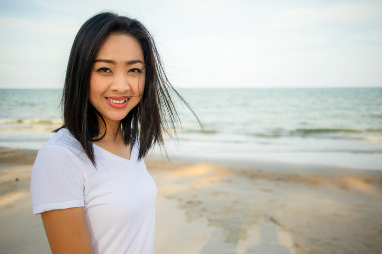 Happy asian woman go for a walk on the beach.