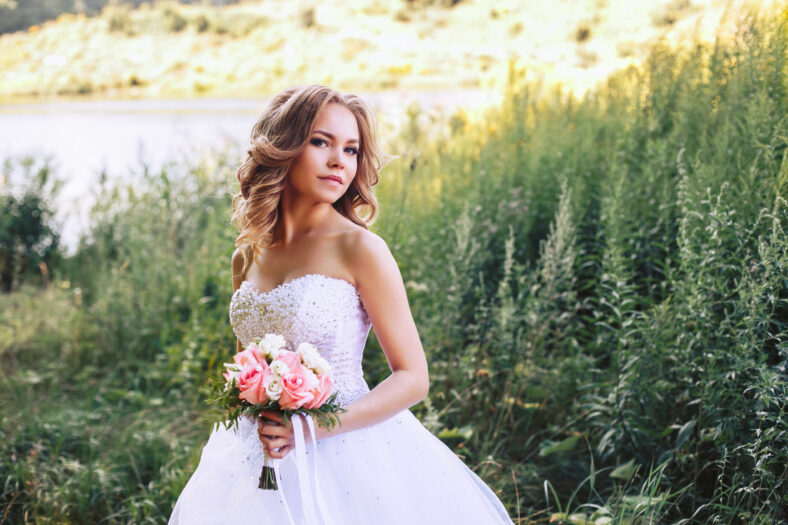 Photo of the bride in nature with a beautiful bouquet