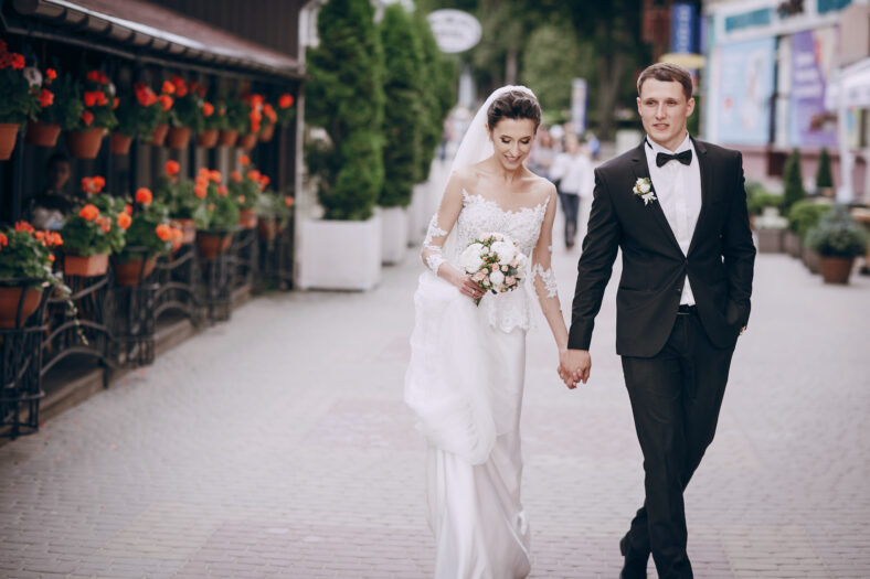 bride and groom walking around the city with a bouquet