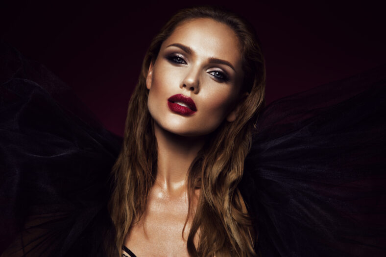 Close-up portrait of beautiful woman with bright make-up and red lips