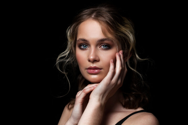 Make up beauty. Close up beautiful blonde fashion model in studio portrait on black isolated background