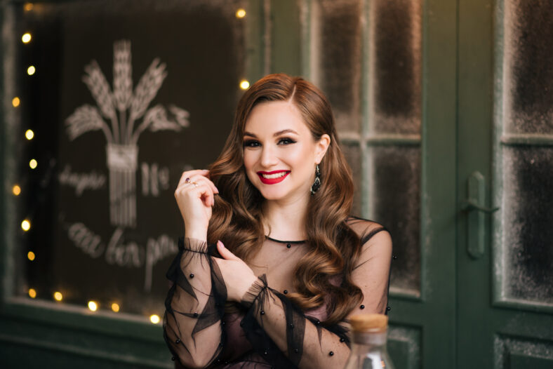 Portrait of a beautiful brunette with curls and red lipstick