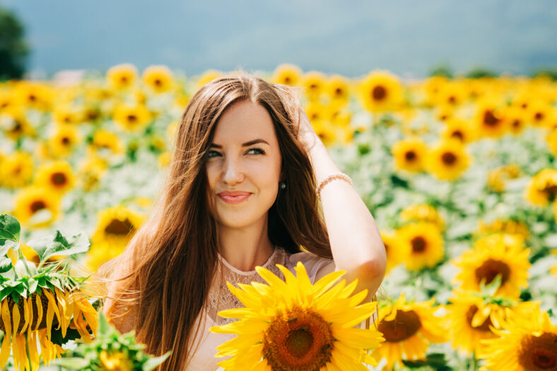 Retrato al aire libre de hermosa mujer joven con girasoles, salud y estilo de vida