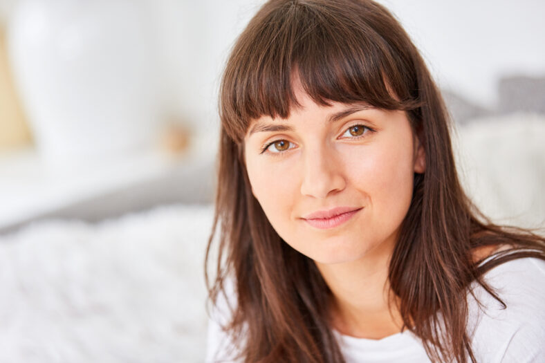 Retrato de una mujer joven con cabello largo y castaño