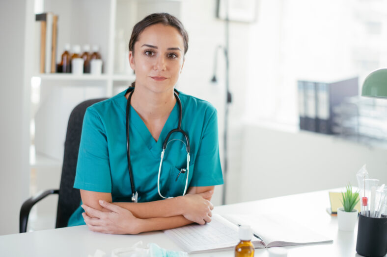 Young female doctor in medical office. Portrait of beautiful female doctor sitting in the clinic office.