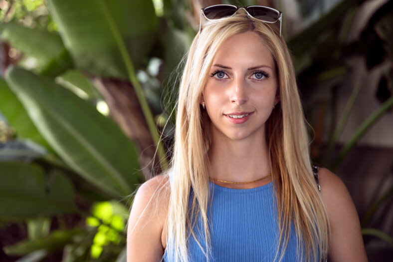 Bright portrait of an attractive blonde woman smiling conservatively by the ocean somewhere at the shores of Northern California, United States of America