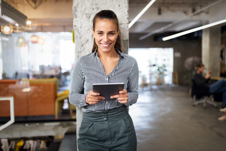 Close up portrait of a young business woman using digital tablet in office